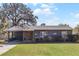 Single-story home featuring a quaint front porch, lovely landscaping, and attached carport at 15 Volusia Dr, Debary, FL 32713