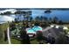Aerial view showcases a community pool, mini golf, and clubhouse, surrounded by lush landscaping and sparkling lake at 15531 Waterleigh Cove Dr, Winter Garden, FL 34787