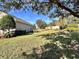 Expansive backyard features lush green lawn, mature trees, and privacy fence; ideal for outdoor activities at 15531 Waterleigh Cove Dr, Winter Garden, FL 34787