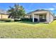 Spacious backyard with lush green lawn, covered patio and manicured landscaping, perfect for outdoor entertaining at 15531 Waterleigh Cove Dr, Winter Garden, FL 34787