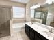 Bathroom featuring double vanity, soaking tub, tiled shower, and a large window for ample natural light at 15531 Waterleigh Cove Dr, Winter Garden, FL 34787