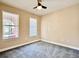 Bright, cozy bedroom with neutral walls, plush carpet, and two windows offering plenty of natural light at 15531 Waterleigh Cove Dr, Winter Garden, FL 34787