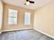 Neutral bedroom with two windows allowing ample natural light and ceiling fan at 15531 Waterleigh Cove Dr, Winter Garden, FL 34787