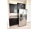 Close-up of a stainless steel refrigerator next to matching cabinets with granite countertop at 15531 Waterleigh Cove Dr, Winter Garden, FL 34787