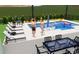 Backyard pool with in-pool seating, sun loungers, outdoor seating, and lush landscaping at 3867 Grassland Loop, Lake Mary, FL 32746