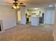 Bright living room featuring carpet, ceiling fan, fireplace, and open concept to a modern kitchen at 485 Forestway Cir # 202, Altamonte Springs, FL 32701