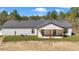 Back exterior view of modern white farmhouse with covered porch, black trim and wooden posts at 8827 Sw 137Th Ct, Dunnellon, FL 34432