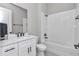Modern bathroom with white subway tile, a soaking tub, and a single sink vanity provides a clean aesthetic at 8827 Sw 137Th Ct, Dunnellon, FL 34432