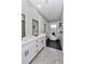 Bathroom with dual sink vanity, wood look floors, subway tile and a soaking tub with black fixtures at 8827 Sw 137Th Ct, Dunnellon, FL 34432