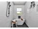 Close-up of a white bathtub with black hardware in a modern bathroom with subway tile at 8827 Sw 137Th Ct, Dunnellon, FL 34432