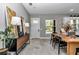 View of the dining table, modern decor, and a glimpse of the bright, airy kitchen at 8827 Sw 137Th Ct, Dunnellon, FL 34432