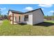 Side view of a modern home with a covered porch, wooden beams, and a well-kept lawn at 8827 Sw 137Th Ct, Dunnellon, FL 34432