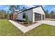 Modern farmhouse exterior with black garage doors, white siding, and a well-manicured lawn at 8827 Sw 137Th Ct, Dunnellon, FL 34432