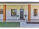 Inviting front entrance with a stylish door flanked by wood columns and planters at 8827 Sw 137Th Ct, Dunnellon, FL 34432