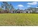 Lovely modern white farmhouse with black trim and wooden columns, set on a expansive green lawn at 8827 Sw 137Th Ct, Dunnellon, FL 34432