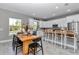 Dining area with a view to the bright kitchen, showcasing modern white cabinets and a scenic window view at 8827 Sw 137Th Ct, Dunnellon, FL 34432