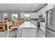 Bright kitchen featuring white cabinetry, stainless steel appliances, and an island with barstool seating at 8827 Sw 137Th Ct, Dunnellon, FL 34432