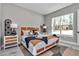 Comfortable bedroom featuring neutral colors, a large window, and stylish furnishings at 8827 Sw 137Th Ct, Dunnellon, FL 34432