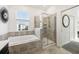 Bright bathroom featuring a soaking tub and frameless glass shower with tiled surround at 953 Splash Shot Pl # 953, Davenport, FL 33896