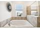 Bright bathroom highlighting a soaking tub, shower, and large window view at 953 Splash Shot Pl # 953, Davenport, FL 33896