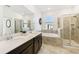 Spacious bathroom with double vanity, tub, glass shower, and neutral tile finishes at 953 Splash Shot Pl # 953, Davenport, FL 33896