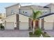 Well-maintained townhomes with stone accents, two car garages, red doors, and manicured lawns at 953 Splash Shot Pl # 953, Davenport, FL 33896