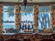 Close up of the dining area showcasing scenic water views from the butterfly curtained bay windows at 100 Blue Lake Ct, Longwood, FL 32779