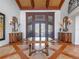 Spacious foyer featuring wood floors, elegant decor, and grand wood and glass front doors at 100 Blue Lake Ct, Longwood, FL 32779