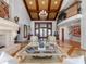 Bright living room with fireplace, wood beam ceiling, and large windows overlooking manicured landscaping at 100 Blue Lake Ct, Longwood, FL 32779