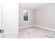 Bright bedroom with wood-look flooring and a window offering a view of the greenery at 12561 Sw 81St St, Dunnellon, FL 34432