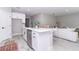 Modern kitchen island with seating, stainless steel dishwasher, white cabinetry, and open to living area at 12561 Sw 81St St, Dunnellon, FL 34432