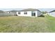 Backyard featuring a sliding glass door and spacious green lawn at 1324 Oak Valley Dr, Auburndale, FL 33823