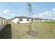 Spacious backyard with newly planted tree and partial fencing, perfect for outdoor activities at 1324 Oak Valley Dr, Auburndale, FL 33823