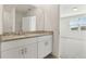 Bathroom with dual sink vanity, granite countertops and view into bedroom at 1324 Oak Valley Dr, Auburndale, FL 33823