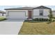 Inviting single-story home featuring a two-car garage, well-kept lawn, and neutral color scheme at 1324 Oak Valley Dr, Auburndale, FL 33823
