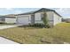 Inviting single-story home featuring a two-car garage, and neutral color scheme with lawn at 1324 Oak Valley Dr, Auburndale, FL 33823