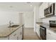 Kitchen features an island with granite countertops, stainless steel microwave and oven, and white cabinets at 1324 Oak Valley Dr, Auburndale, FL 33823