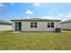 Backyard features lush green grass, a patio, and view of the rear exterior at 1337 Oak Valley Dr, Auburndale, FL 33823
