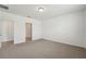 A light-filled bedroom with neutral carpet, white walls, and doorways leading to other rooms at 1337 Oak Valley Dr, Auburndale, FL 33823