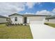 Charming single-story home with a well-manicured lawn and a two-car garage on a sunny day at 1337 Oak Valley Dr, Auburndale, FL 33823