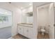 Bright bathroom featuring a double vanity, tile flooring, and an adjacent toilet room at 1341 Oak Valley Dr, Auburndale, FL 33823