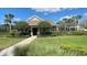 Community clubhouse featuring manicured shrubs and palm trees, and an accessible sidewalk at 1727 Saffron Plum Ln, Orlando, FL 32828