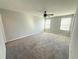 Spacious bedroom featuring a ceiling fan, carpet, and bright natural light from two windows at 2906 Fieldwood Cir, St Cloud, FL 34772