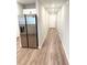 Hallway with stainless steel refrigerator, white door, and wood-look flooring at 2906 Fieldwood Cir, St Cloud, FL 34772