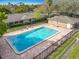 An aerial view of the community pool, surrounding buildings, landscaping, and fence at 542 Cascade Cir # 102, Casselberry, FL 32707