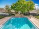 Beautiful in-ground community pool with brick trim, chairs, and serene landscaping at 542 Cascade Cir # 102, Casselberry, FL 32707