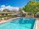Community pool with brick surround, black metal fence, lounge chairs, and mature trees at 542 Cascade Cir # 102, Casselberry, FL 32707