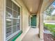 Charming covered entrance features a bright green door, complemented by lush landscaping and natural light at 542 Cascade Cir # 102, Casselberry, FL 32707
