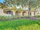 Inviting home exterior showcasing an arched portico, lush lawn, and mature landscaping creating curb appeal at 542 Cascade Cir # 102, Casselberry, FL 32707
