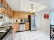 Bright kitchen with stainless steel appliances, light wood cabinetry, and tile flooring at 542 Cascade Cir # 102, Casselberry, FL 32707